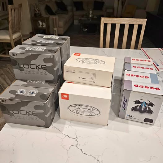 Assorted drone model boxes stacked, with circular drone artwork on packaging