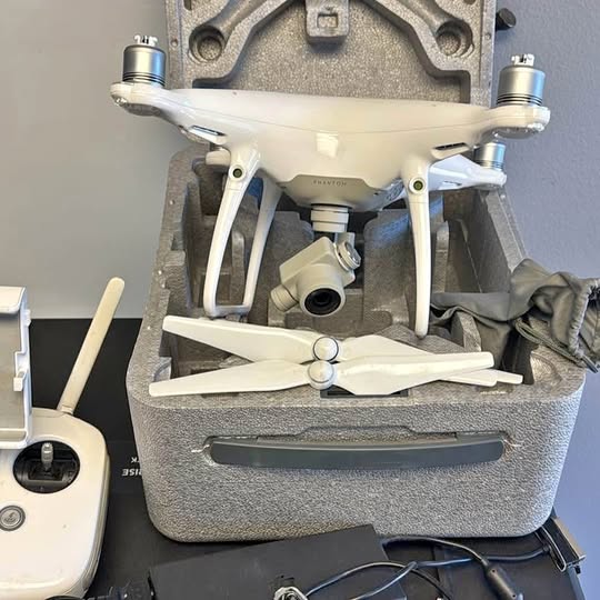 White quadcopter drone with 4 propellers and front gimbal camera