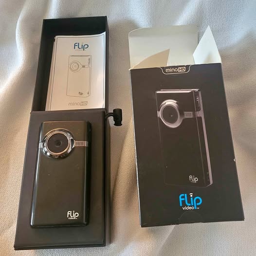Digital flip video camcorder with flip screen, black, shown in retail packaging