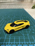 Yellow diecast toy car model with black roof and hood details, small 1:64 scale