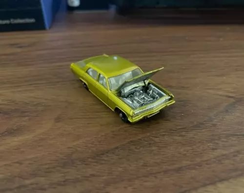 Lime green vintage diecast car with hood open, front three-quarter view