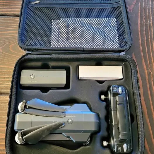 Drone carrying case with folded quadcopter, controller, and battery compartments