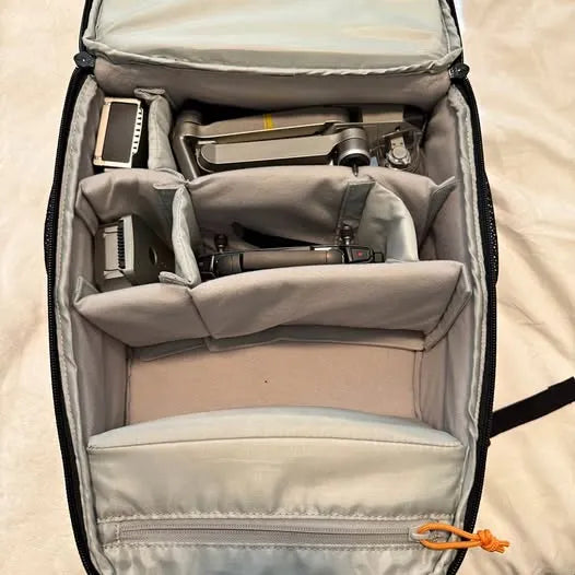 Padded drone carrying case with open compartments and gray interior lining