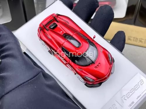 Red diecast sports car model with open detailing on white display card