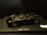 Diecast Pagani Huayra 2012 car, dark body with gold accents, front 3/4 view