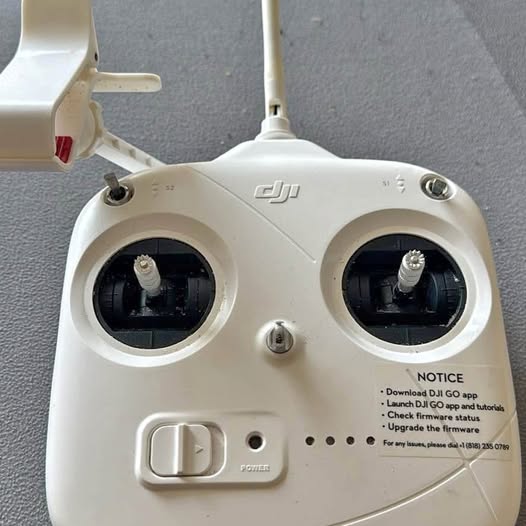 DJI Phantom white remote controller with two control sticks and circular gimbal ports