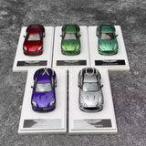 Diecast sports car models in display trays, red, green, purple and silver