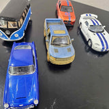Diecast cars in blue, orange, yellow, and white with stripes, toy vehicle models.