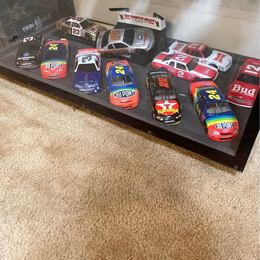 NASCAR diecast car lot with multiple red, blue, and black race cars on display tray