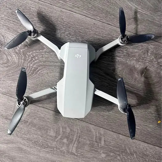 White quadcopter drone with four propellers and gimbal body