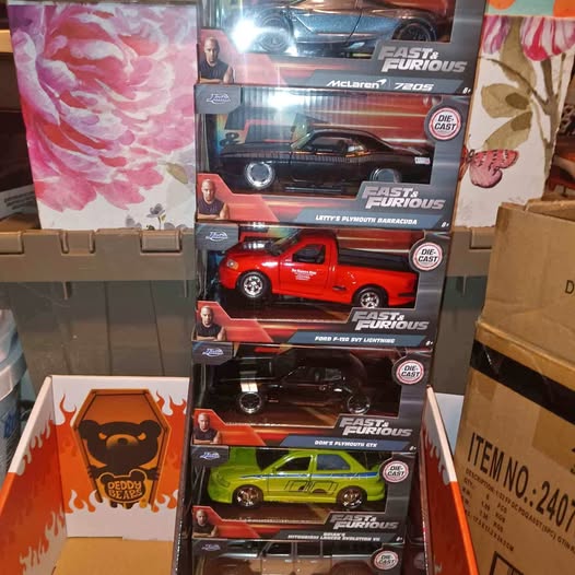 Diecast car set in retail box with visible red and green toy cars