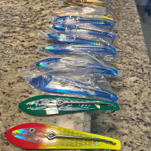Assorted spoon trolling lures in plastic bags, blue green yellow red with treble hooks
