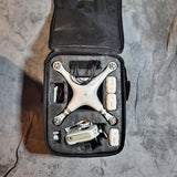 White drone in black hard-shell carry case with fitted foam compartments