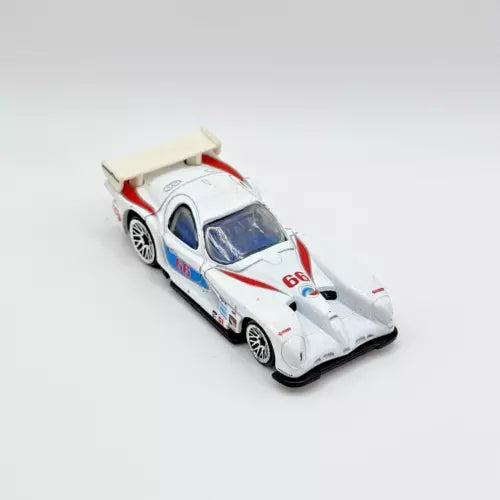 White diecast race car with red accents, number 657, 1:64 scale