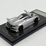 Silver 1:64 scale diecast sports car model with hood open on display base
