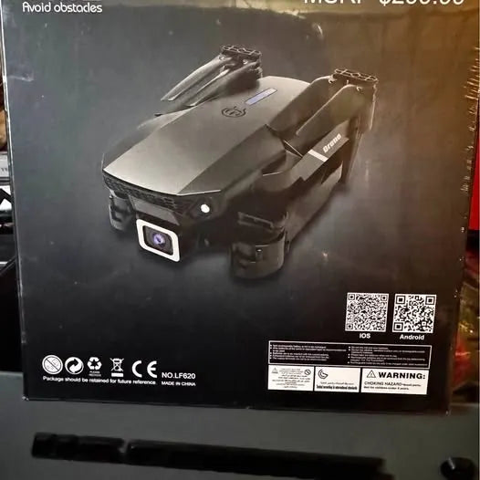 Foldable black quadcopter drone with front camera, shown on retail box