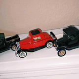 Red vintage diecast pickup model car with black roof and chrome wheels