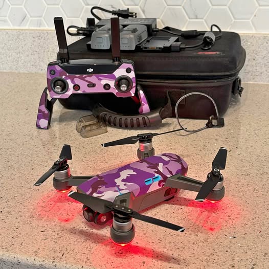 Purple camouflage quadcopter drone with four propellers and LED lights