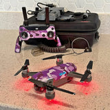 Purple camouflage quadcopter drone with four propellers and LED lights