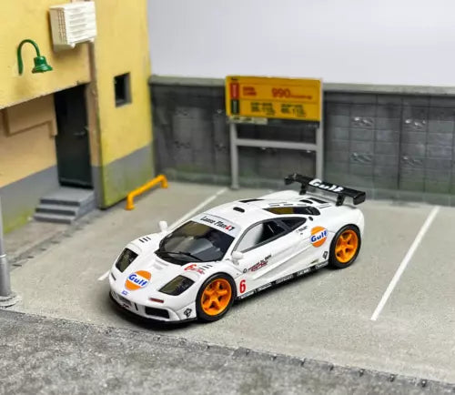 White racing diecast model car with Gulf graphics, black hood, orange wheels