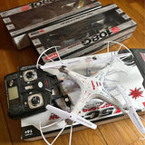White quadcopter drone with red accents, with remote controller and packaging