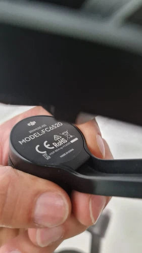 Black gimbal camera module with round model label on underside