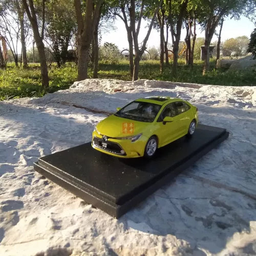 Green diecast model car with molded front grille on black display base