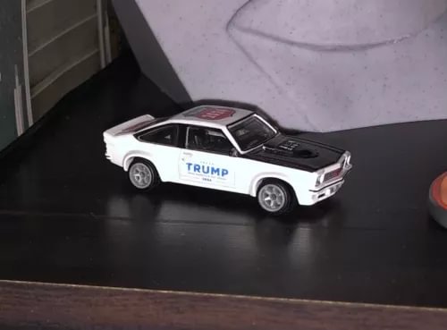 Diecast model car, white with black hood and Trump door graphics