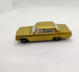 Diecast vintage car, gold/yellow body with dark wheels, side view, closed hood