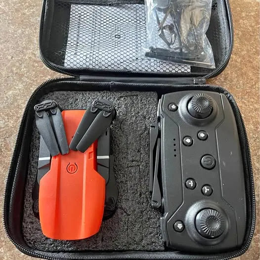 Orange folding drone and black controller in zipped carrying case with mesh pocket