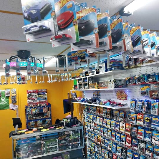 Diecast toy cars in blister packs on store display shelves