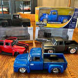 Diecast Ford pickup truck, blue with open bed; red truck model beside