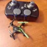 Mini quadcopter drone with green and black body, four propellers