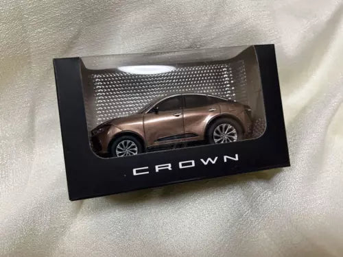 Diecast toy car in box, metallic brown coupe with 'CROWN' on packaging