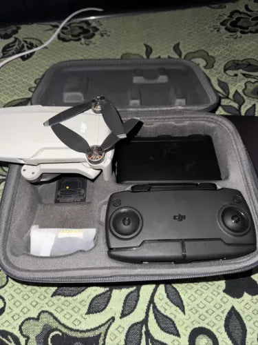 Grey drone with camera, folded propellers, inside gray hard carrying case