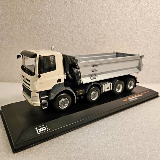 White diecast dump truck model with gray dump bed, detailed wheels and cab