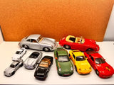 Assorted diecast toy car models in silver, green, yellow, and red