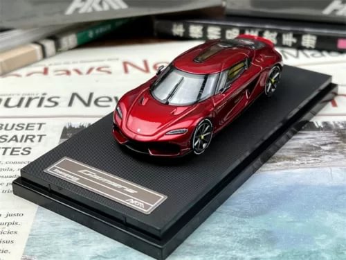 Red diecast sports car model on black display base, 1/64 scale