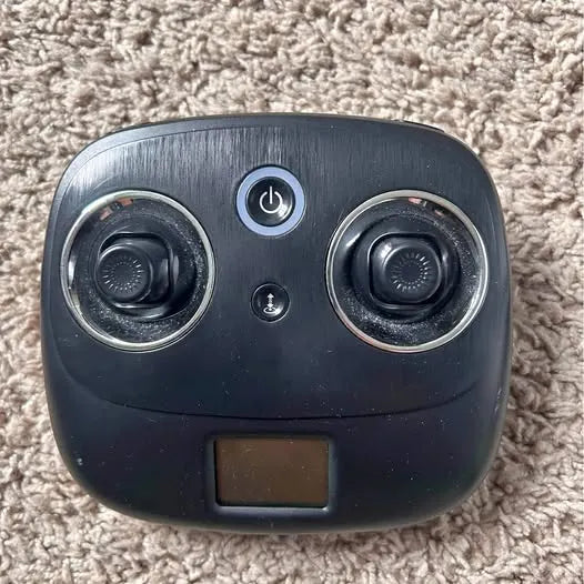 Drone remote controller with power button, thumb sticks, and small screen