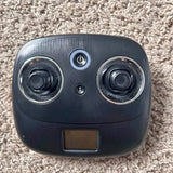 Drone remote controller with power button, thumb sticks, and small screen