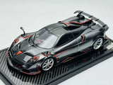 Met carbon black diecast model car with red racing accents, on display base