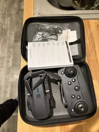 Drone in zippered carrying case with controller and spare parts