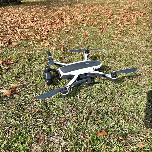 White quadcopter drone with 3-blade propellers and mounted camera gimbal