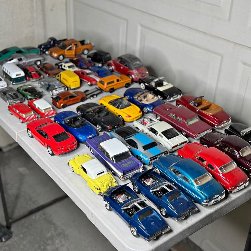 Diecast model car collection with multiple colorful vehicles on a display tray