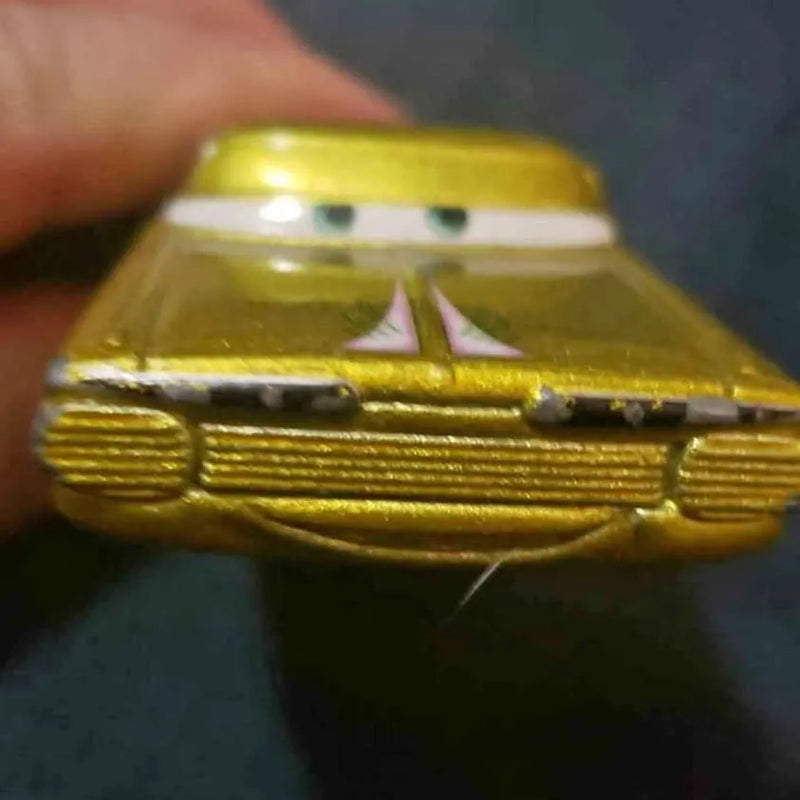 Gold diecast car with detailed grille and headlights, front three-quarter view