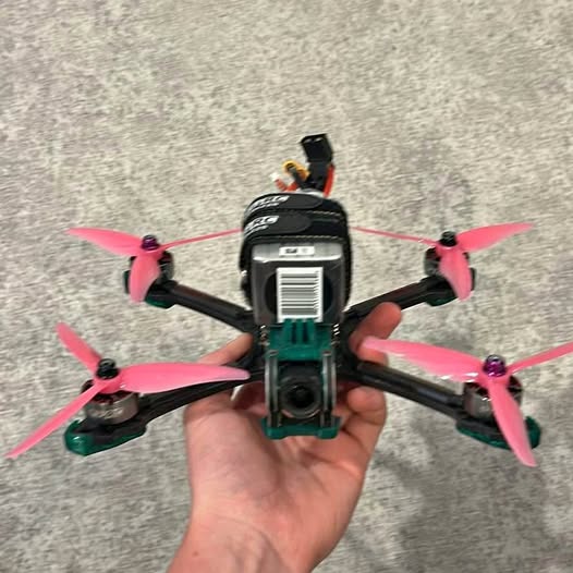 Quadcopter drone with four pink propeller blades and front camera module