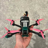 Quadcopter drone with four pink propeller blades and front camera module
