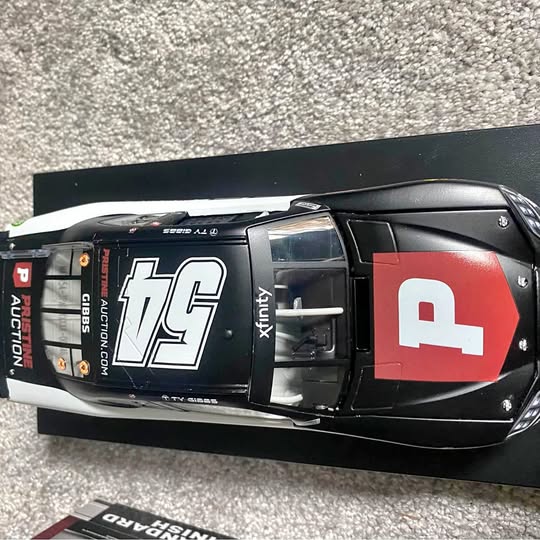 1/24 scale diecast race car, black with red and white graphics on hood
