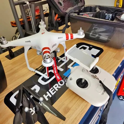White quadcopter drone with red accents, four propellers, front camera gimbal