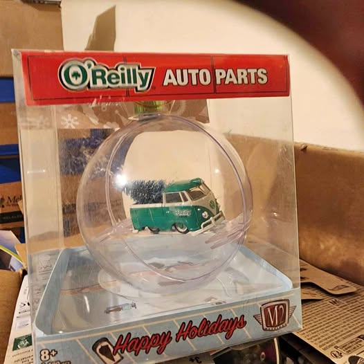 Green diecast vehicle model in clear box with Happy Holidays band